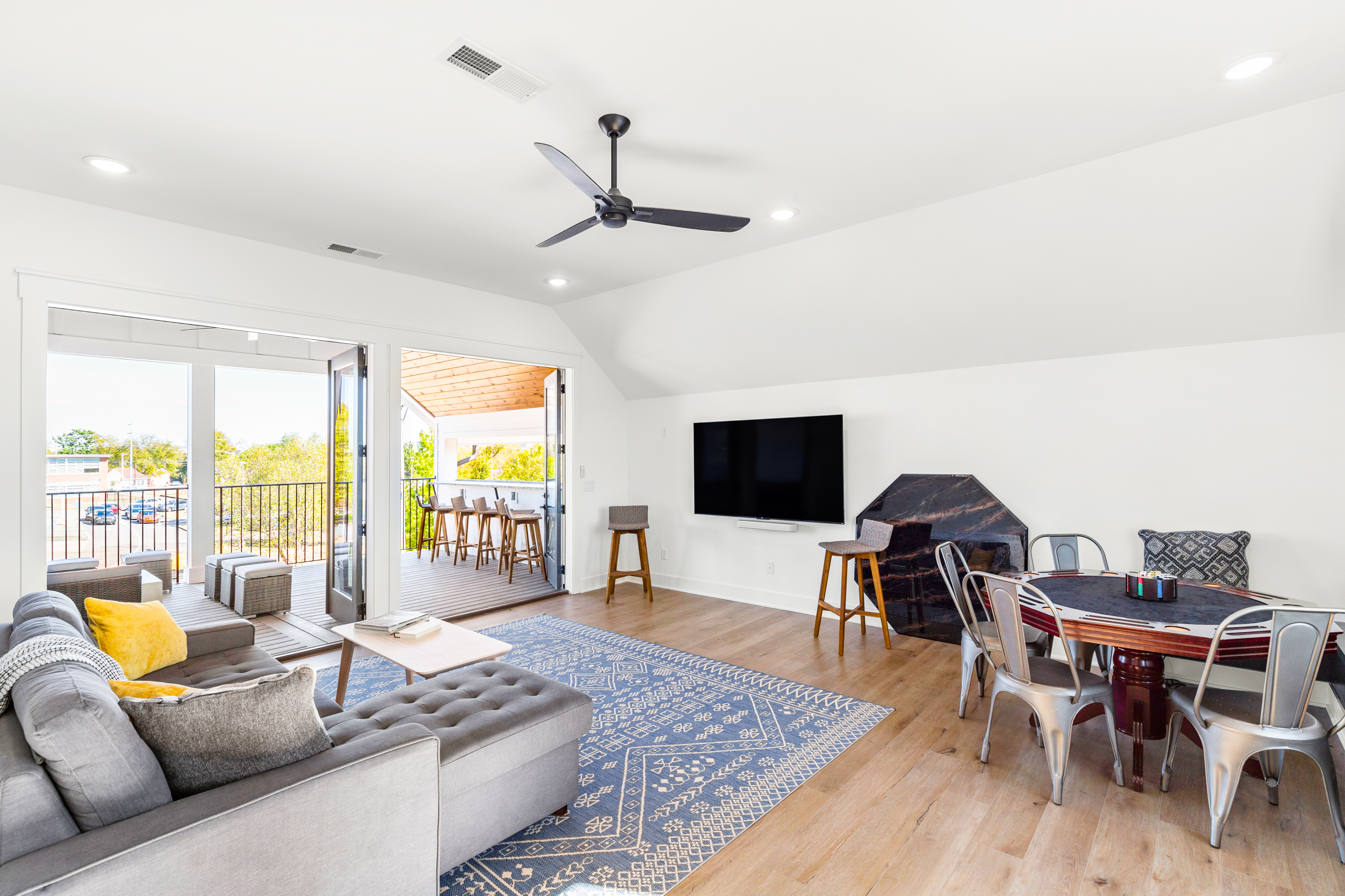 Spacious living area with poker table, TV, and outdoor access